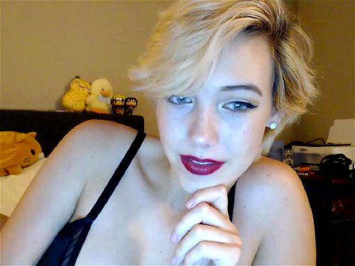 Busty short-haired blonde Lyra Emotte teases on bed
